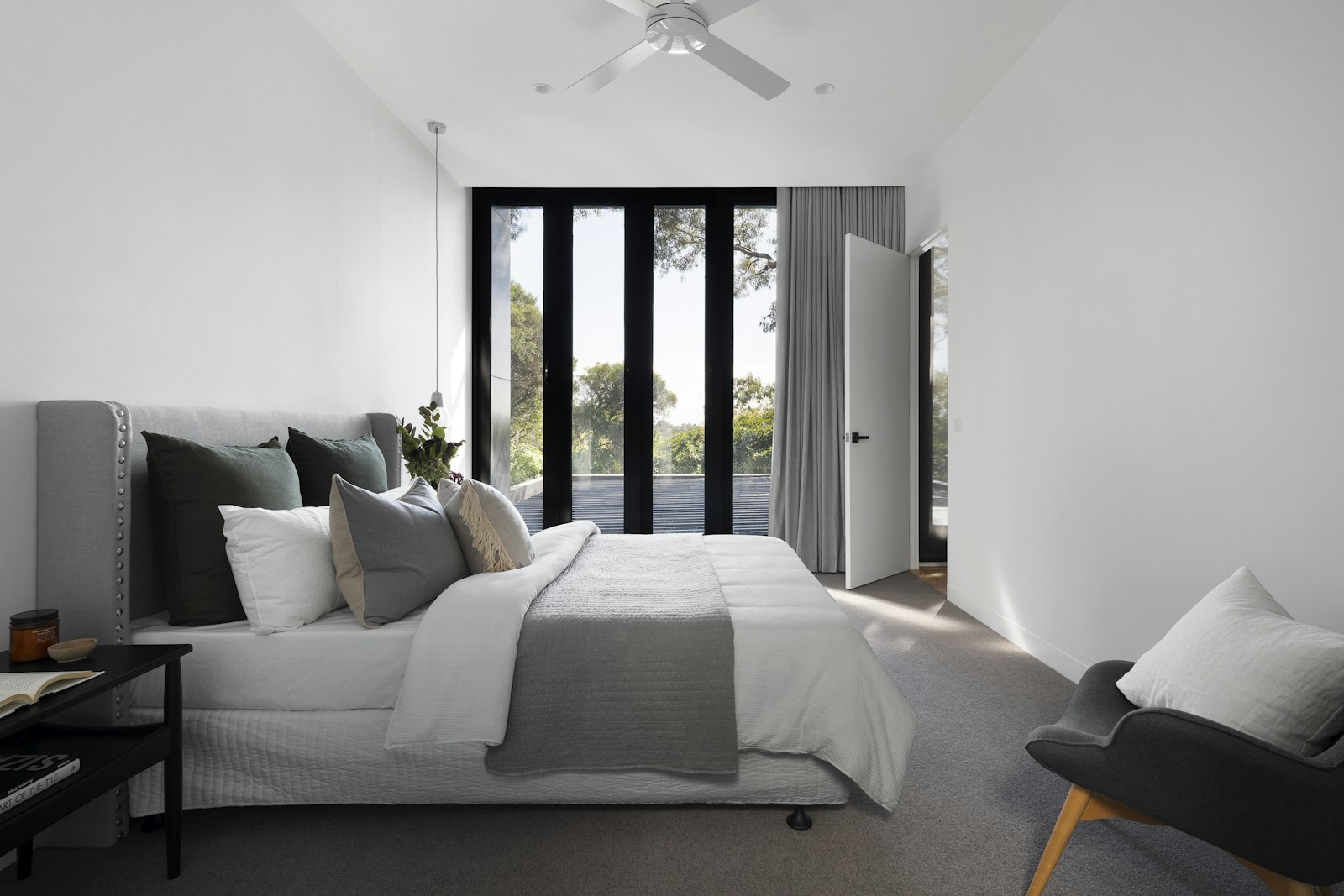 Pale living space with a sculptural chair and soft daylight